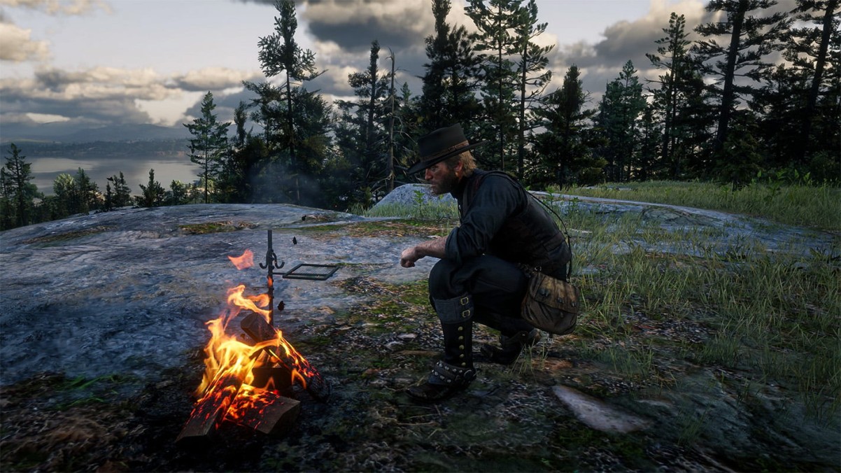 Arthur Morgan resting by a campfire in Red Dead Redemption 2, showing the game’s cinematic atmosphere and emotional storytelling