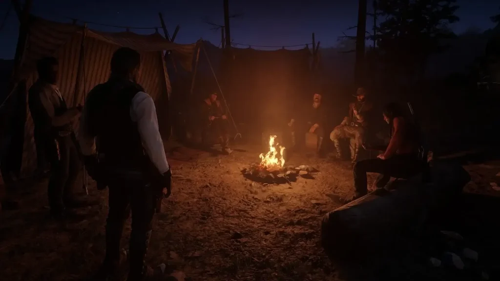 Arthur Morgan standing in camp at night with lantern lighting in Red Dead Redemption 2